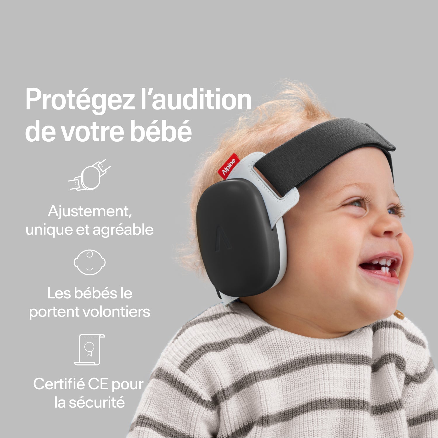 Bébé heureux portant des protège-oreilles Alpine black, ajustement sécurisé, protection auditive certifiée CE