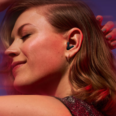 Close-up of a person wearing a wireless earbud with a blurred background