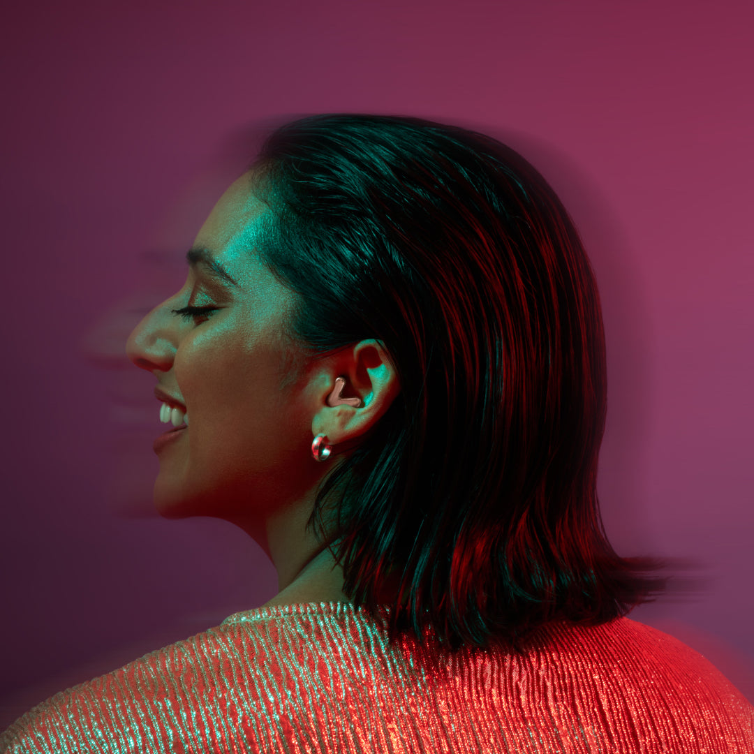 Woman wears Alpine Tune in rose gold while dancing