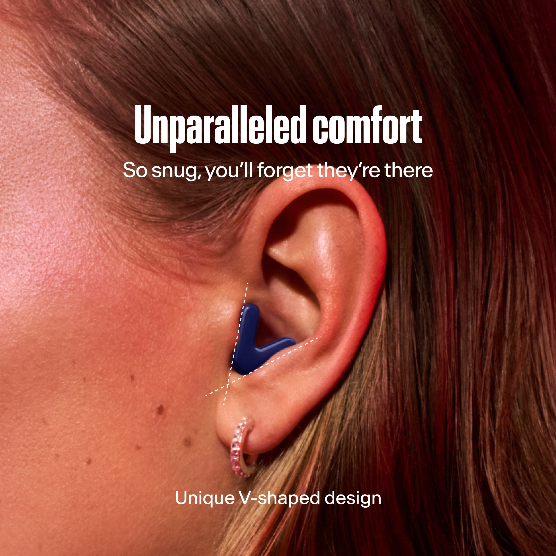 Detailed image of an ear with an Alpine Tune earplug in dark blue showing the snug fit in ear