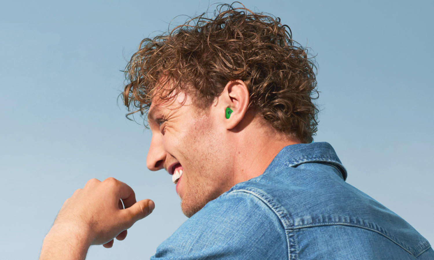 lachende man met gruene op maat gemaakte oordoppen